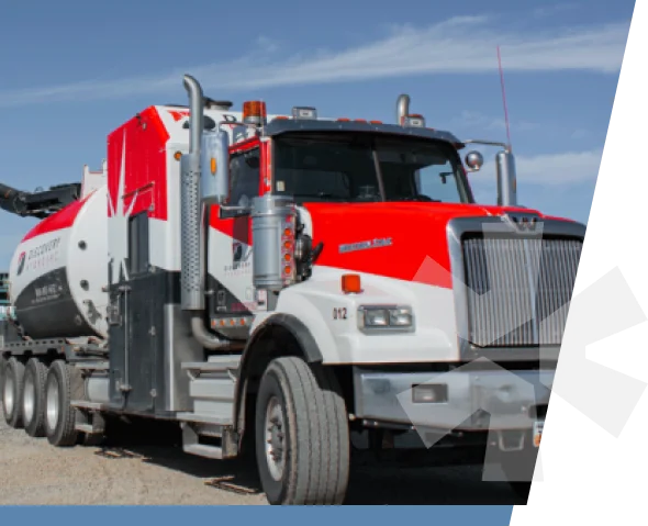 A red and white Tri State Hydrovac vacuum truck parked on a gravel yard under a clear sky